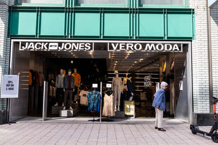 Hamburg, Germany - August 23, 2019: Facade of a Jack and Jones clothing store with a senior woman...