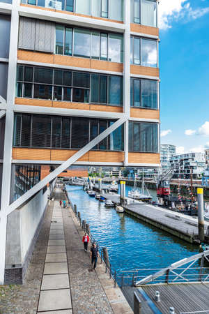 Hamburg, Germany - August 21, 2019: Modern buildings and a pier with boats and people around next to a canal in the neighborhood of HafenCity, Hamburg, Germanyのeditorial素材