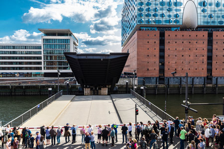 Hamburg, Germany - August 21, 2019: Facade of the Elbphilharmonie, Elbe Philharmonic Hall, and opened Mahatma Gandhi Bridge with people waiting in HafenCity, Hamburg, Germanyのeditorial素材
