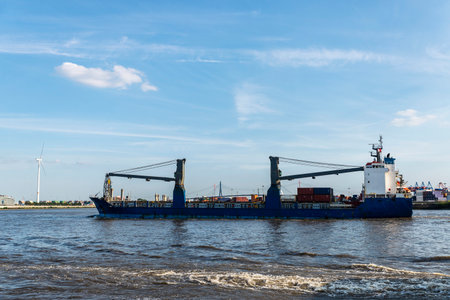 Cargo ship with containers sailing in the port on the Elbe river in Hamburg, Germany