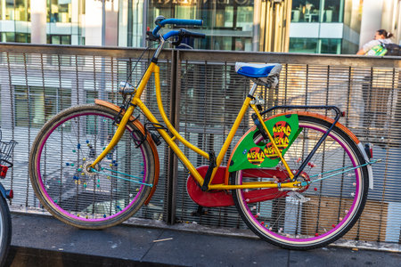 Hanover, Germany - August 19, 2019: Old multicolor vintage bicycle parked on a bridge with people around in Hanover, Germanyのeditorial素材