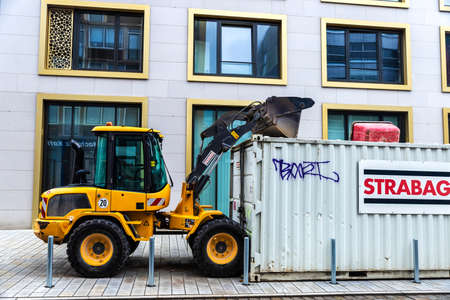 Hanover, Germany - August 18, 2019: Shovel of a yellow excavator on a container on a street in the center of Hanover, Germanyのeditorial素材