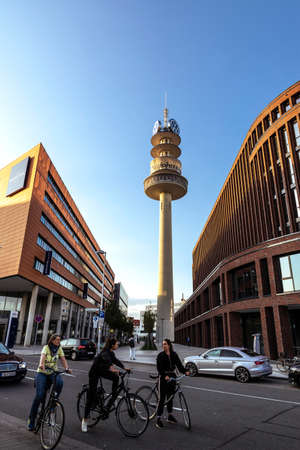 Hanover, Germany - August 19, 2019: View of the VW-Tower, radio telecommunications tower and three women on bike in Hanover, Germanyのeditorial素材