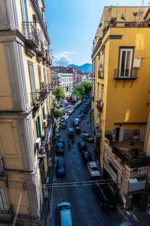 Naples, Italy - September 6, 2019: Overview of a street of classic buildings with people around and the Mount Vesuvius in the old town of Naples, Italyのeditorial素材