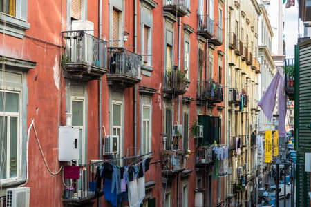 Naples, Italy - September 6, 2019: Facade of classic buildings with hanging clothes and women on the balcony in the historical center of Naples, Italyのeditorial素材