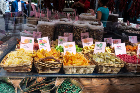 Naples, Italy - September 9, 2019: Vendor in a dried fruit shop on a street food market with people around in Via Toledo, Naples, Italyのeditorial素材