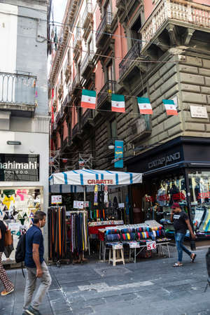 Naples, Italy - September 9, 2019: Via Toledo, shopping street with a stall selling belts and ties and people around in the old town of Naples, Italyのeditorial素材