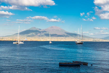 Sailboats, boats and catamarans anchored or sailing on the bay of Naples in front of the Mount Vesuvius, Italyの写真素材