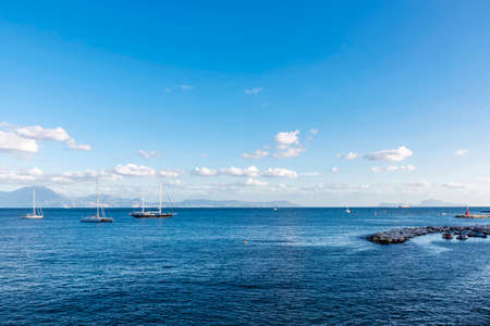 Sailboats and catamarans anchored or sailing on the bay of Naples, Italyの写真素材