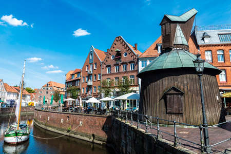 Hansestadt Stade, Germany - August 22, 2019: Old wooden sailboat, medieval houses and restaurants by the canal with people around in the old town of Stade, Lower Saxony, Germanyのeditorial素材