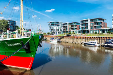 Hansestadt Stade, Germany - August 22, 2019: Modern residential buildings by the canal with ships, sailboats and yachts moored in Hansestadt Stade, Lower Saxony, Germanyのeditorial素材