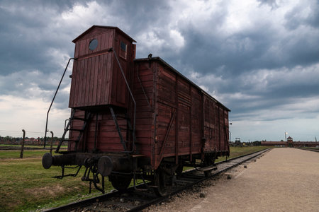 Auschwitz, Poland - August 30, 2018: Freight car in the Auschwitz Birkenau concentration camp at sunset, an extermination camp operated by Nazi Germany during World War II and the Holocaust near Krakow, Polandのeditorial素材