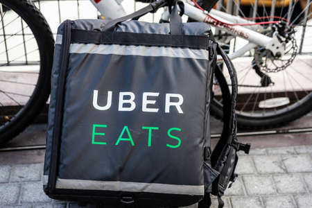 Warsaw, Poland - September 1, 2018: Uber Eats backpack next to a rider bike in Warsaw, Poland