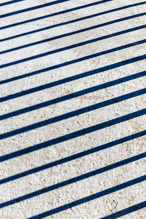 Shadow of parallel lines on a cement surface as abstract backgroundの写真素材