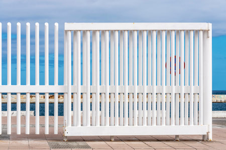 Bars of a white fence against the blue sky and the sea as abstract backgroundの写真素材