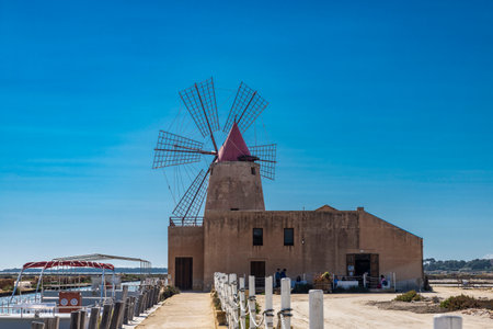 Salt evaporation ponds and big windmill in Marsala, Trapani, Sicily, Italyの写真素材