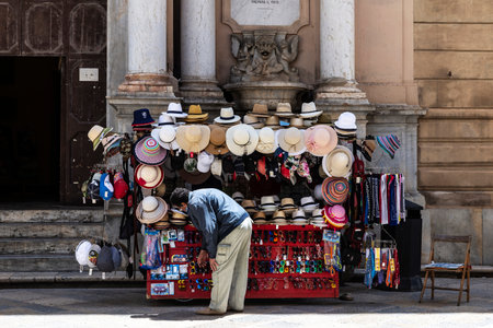 Marsala, Italy - May 11, 2023: Vendor at his stall selling souvenir and panama hat in the old town of Marsala, Trapani, Sicily, Italyのeditorial素材