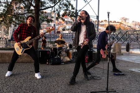 Porto, Portugal - November 24, 2023: Rock band playing in the street next to the Dom Luis I bridge over the Douro river in Porto or Porto, Portugalのeditorial素材