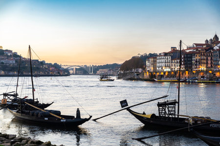 Porto, Portugal - November 24, 2023: View of the The Ribeira area along the Douro river at dusk with cargo boats called Rabelo in Porto or Porto, Portugalのeditorial素材