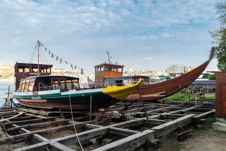 Porto, Portugal - November 26, 2023: Old shipyard along the Douro river with two tour boats in Porto...
