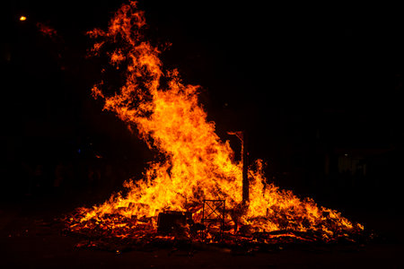People celebrate St John's Eve (Sant Joan) around a bonfire on a street at night, Barcelona,...