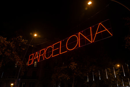 Barcelona, Spain - November 25, 2025: Christmas lights decoration hanging on the street illuminated at night with Barcelona sign in Gran Via, Catalonia, Spainの写真素材