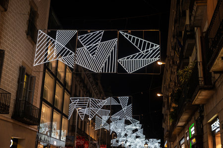Barcelona, Spain - November 25, 2025: Christmas lights decoration hanging on the street illuminated at night in Portal de Angel avenue, Barcelona, Catalonia, Spainのeditorial素材
