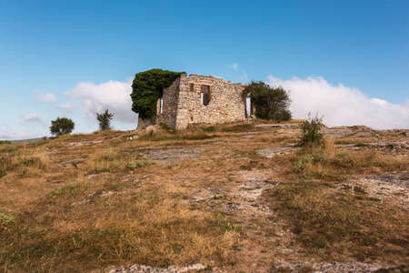 ruins of an old abandoned house in the mountain of La Mussara, tarragona, catalonia, spain. mountain, with blue sky and some cloudsの写真素材