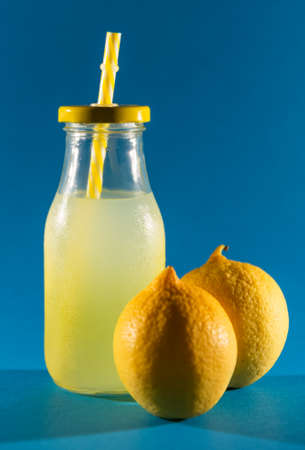 group of six yellow lemons (fruit) and two halves. blue background. studio photo.の写真素材