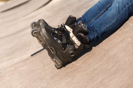 legs with roller skates and blue jeans on a skate park rampの写真素材