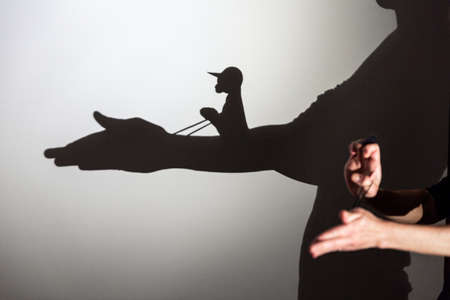 play shadow projected on a white screen. the person's hands shape the horse and riderの写真素材