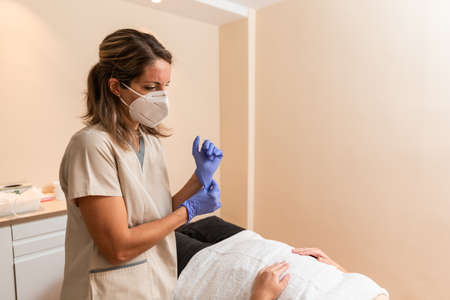 physiotherapist puts the lilac latex gloves next to patient for acupuncture sessionの写真素材