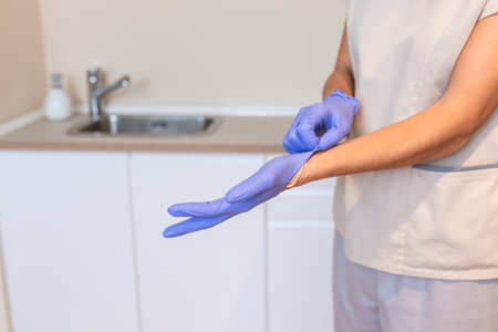 Medicine and professional skills concept. woman physiotherapist puts glove onの写真素材