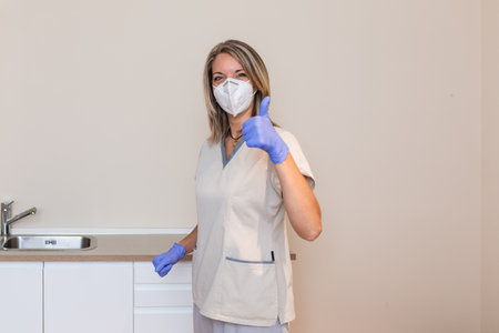Medicine and professional skills concept. woman physiotherapist puts glove onの写真素材