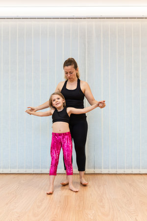mother, yoga and pilates instructor, and daughter, do balance exercisesの写真素材