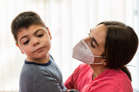 physiotherapy session of disabled child with a physiotherapist, they are huggedの写真素材