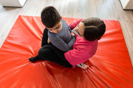 physiotherapy session of disabled child with a physiotherapist, they are huggedの写真素材