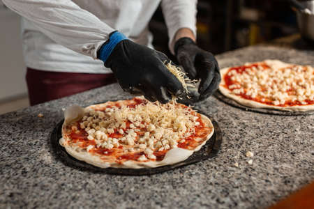 man cook prepares a pizza in a italian restaurant pizzeria