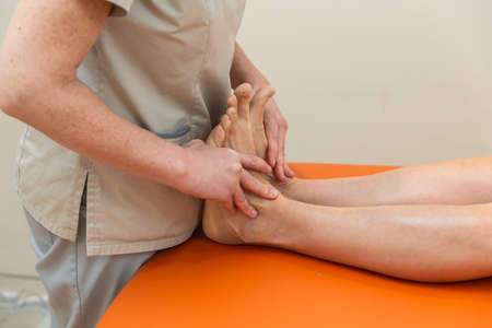 Physiotherapist and patient in Global Postural Re-education session, with pandemic protection mask.の写真素材