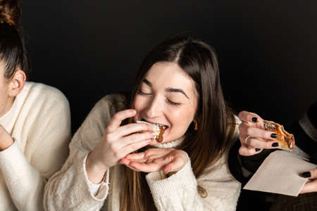 girls eat chocolate cream pizza dessert and get messyの写真素材