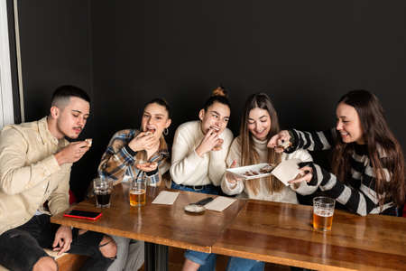 group of friends share and eat chocolate cream dessertsの写真素材