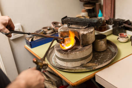 blowtorch melts silver in a jewelry workshop furnaceの写真素材