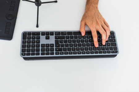 Anonymous male working on computer at table with graphic tablet