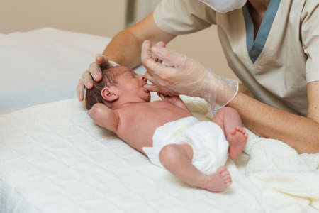 Professional physiotherapist performing a suction assessment in a newborn baby.の写真素材