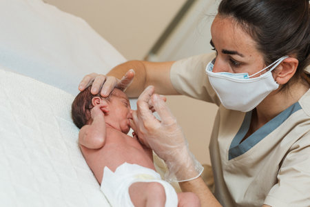 Female physiotherapist performing a suction assessment in a newborn baby in a medical center.の写真素材