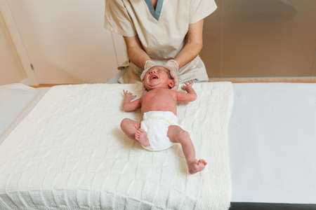 Physiotherapist doing a positional plagiocephaly correction work on a newborn baby.の写真素材