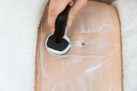 Woman receiving radiofrequency stimulation treatment for faster recovery like for inflammations, pelvic floor, scarringの写真素材