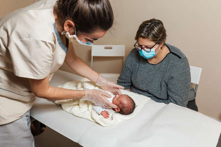 Physiotherapist doing an evaluation of the temporomandibular joints on a baby at a medical center.
