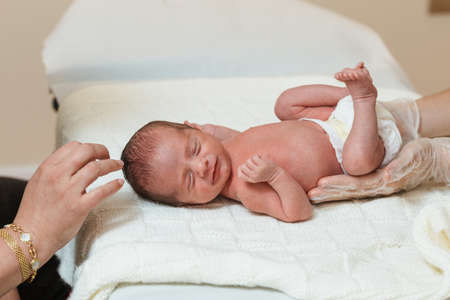 Pediatric physiotherapist performs an evaluation of the primary respiratory movement in a newborn baby.の写真素材
