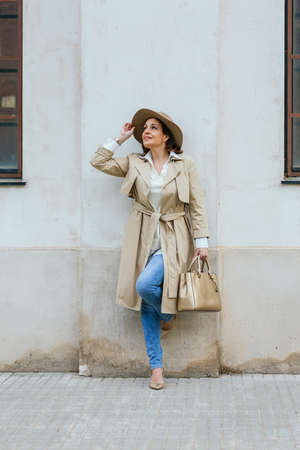 Woman in stylish warm clothes posing outdoors on the street.の写真素材